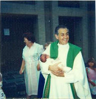 Fr. Troncali holding Megan.